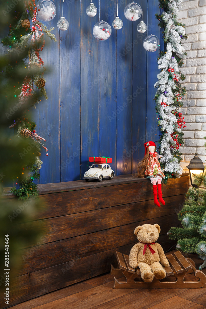 Fototapeta premium christmas tree with colorful balls and gift boxes over blue wooden wall. New Year's toys are waiting for children