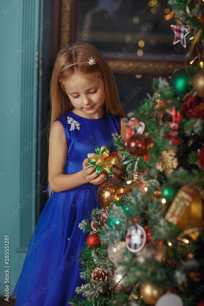 Little blonde girl in blue dress, new year