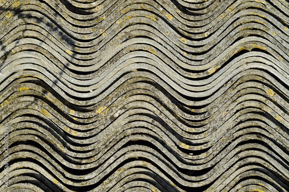 Corrugated slate lies in a pile, side view background texture of slate.