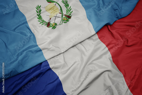 waving colorful flag of france and national flag of guatemala.