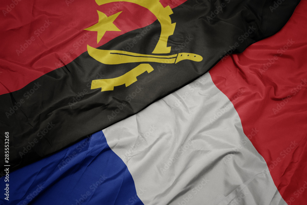 Fototapeta premium waving colorful flag of france and national flag of angola.