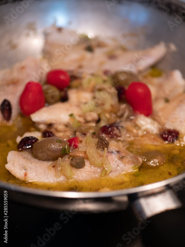 Sautéed cod with tomato, raisins, pine nuts, celery, red onion, oil, pepper and olives and olives