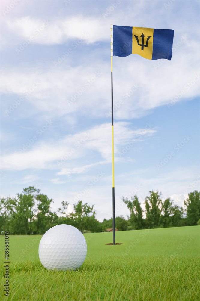 Obraz premium Barbados flag on golf course putting green with a ball near the hole