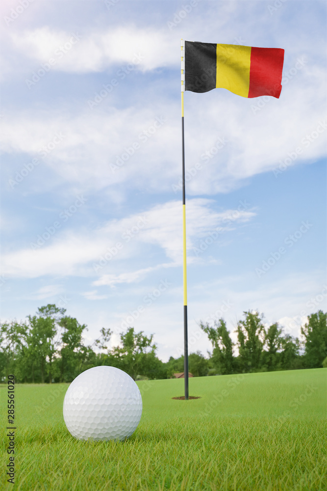 Obraz premium Belgium flag on golf course putting green with a ball near the hole