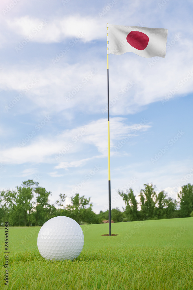 Obraz premium Japan flag on golf course putting green with a ball near the hole