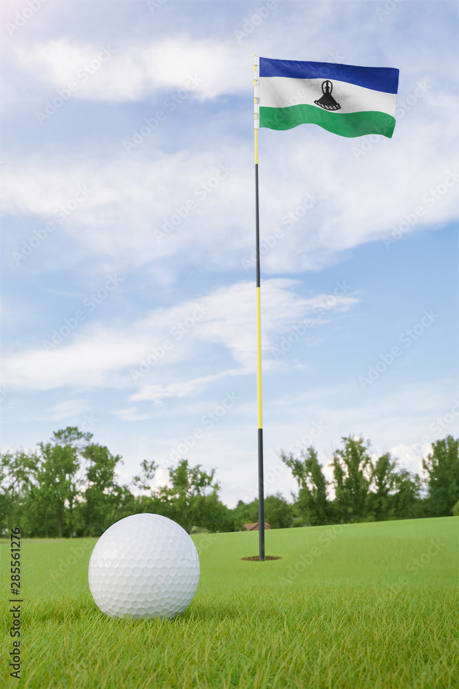 Obraz premium Lesotho flag on golf course putting green with a ball near the hole