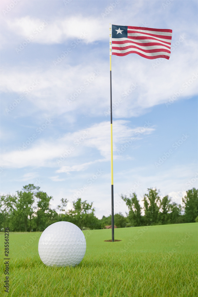 Obraz premium Liberia flag on golf course putting green with a ball near the hole
