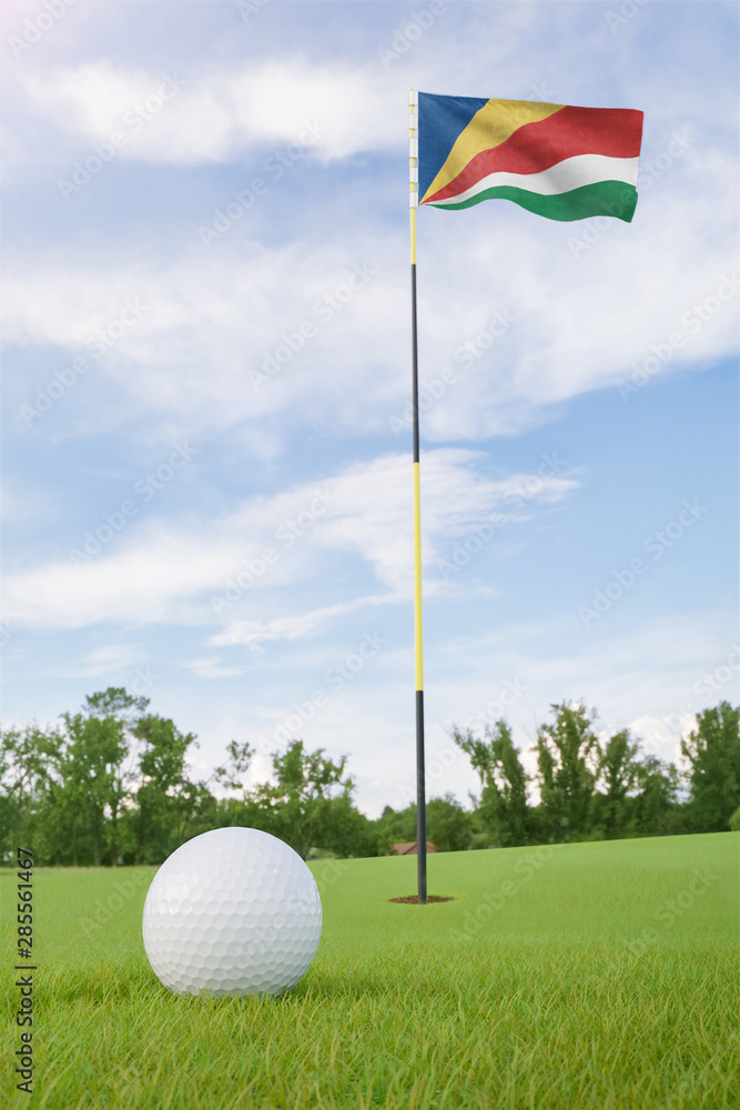Obraz premium Seychelles flag on golf course putting green with a ball near the hole