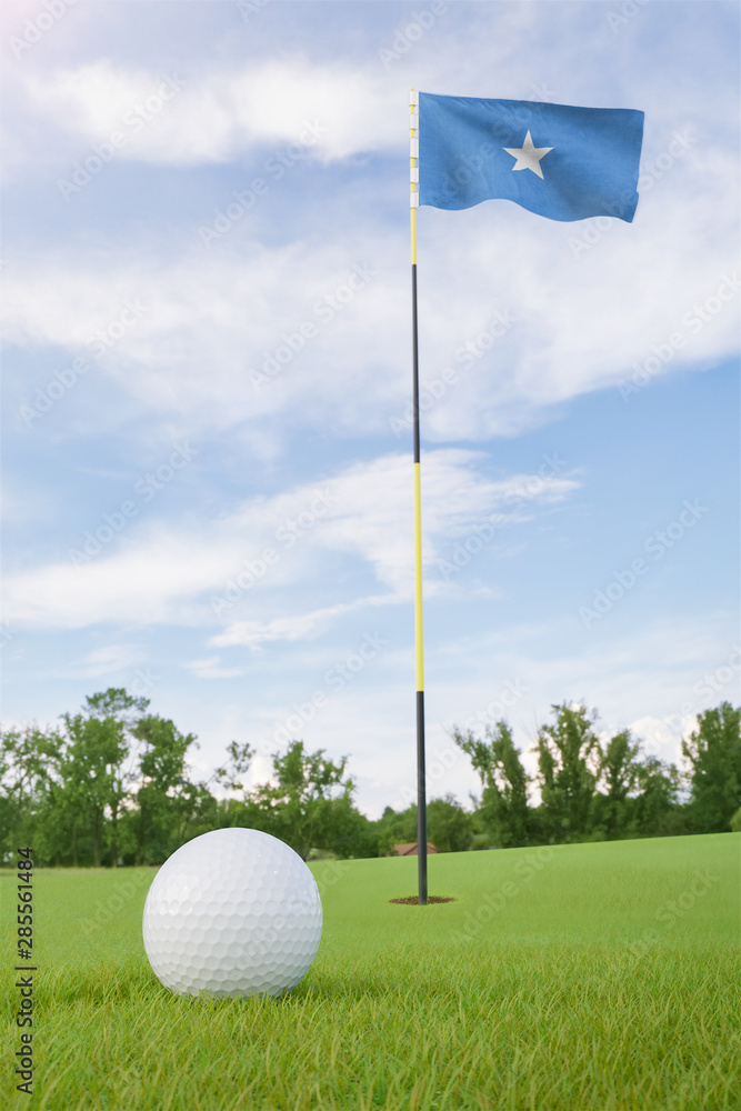 Obraz premium Somalia flag on golf course putting green with a ball near the hole