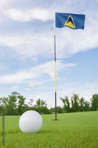 Saint Lucia flag on golf course putting green with a ball near the hole