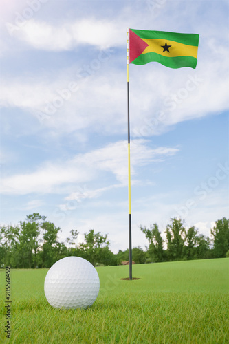 Sao Tome and Principe flag on golf course putting green with a ball near the hole