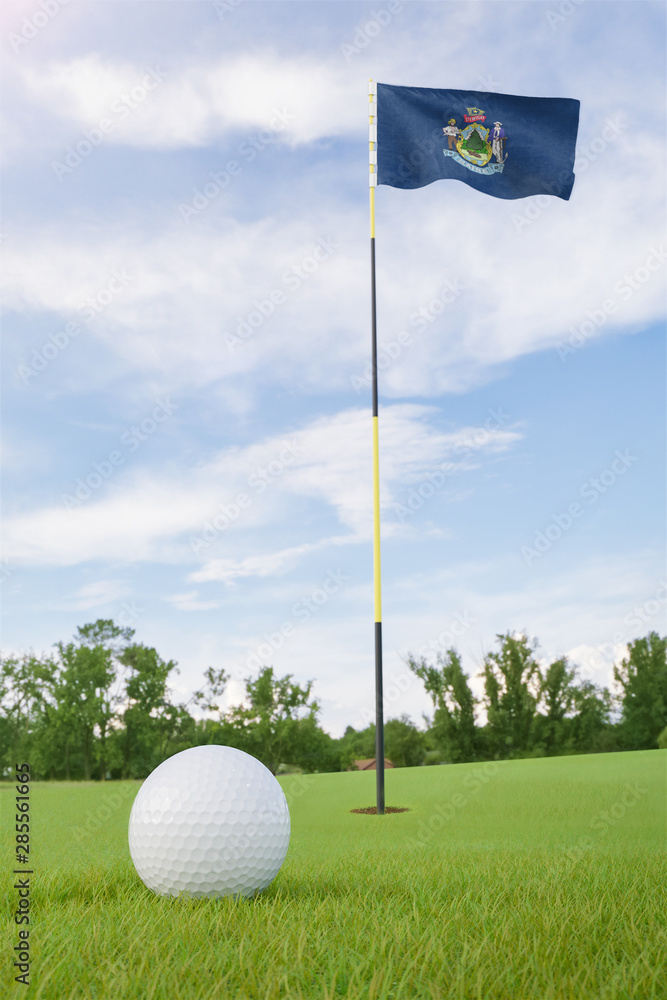 Obraz premium Maine flag on golf course putting green with a ball near the hole