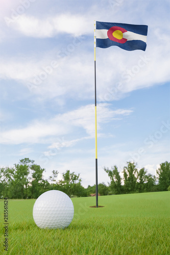 Colorado flag on golf course putting green with a ball near the hole
