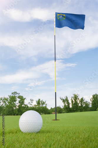 Nevada flag on golf course putting green with a ball near the hole