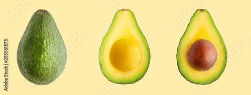 Avocado isolated. Whole avocado fruit and two halves in a row isolated on a yellow background with clipping path
