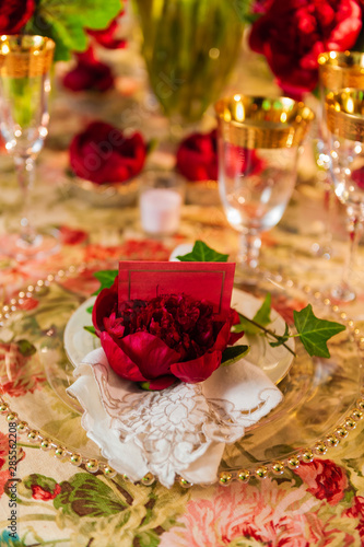 Fancy table setting with red flowers.