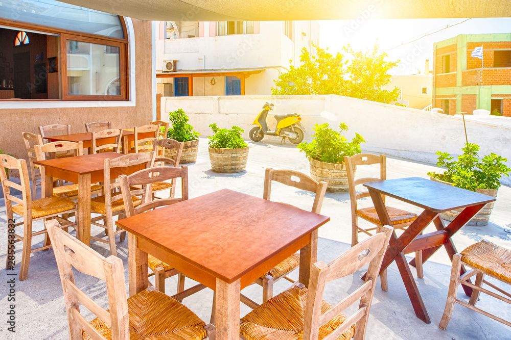 Fototapeta premium Beautiful Sunny Summer Restaurant on Santorini Island in Greece with Scooter on Background.