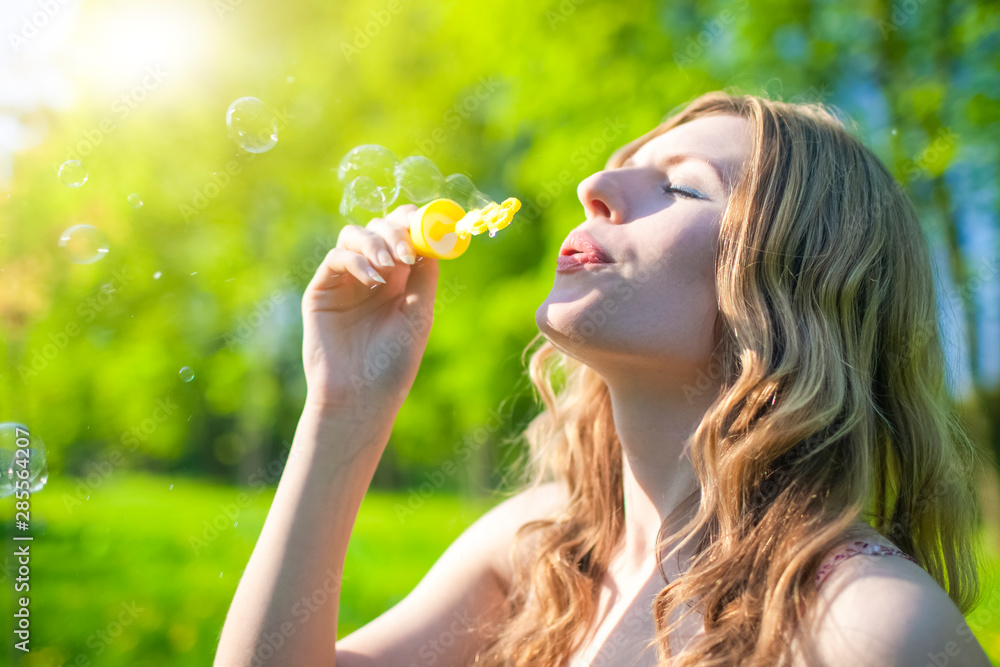 Happy Caucasian Female Blowing Soap Bubbles Outdoors on Meadow. Happy Caucasian Female Blowing Soap Bubbles Outdoors on Meadow.