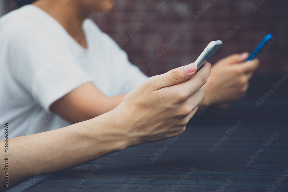 Two young people using a smartphone to chat Two young people using a smartphone to chat