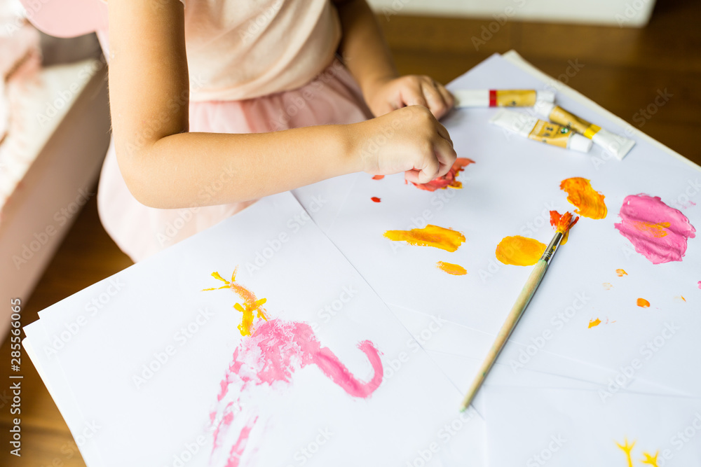 Portrait of a cute little girl painting hands at home. Learn, education, happy childhood concept Portrait of a cute little girl painting hands at home. Learn, education, happy childhood concept
