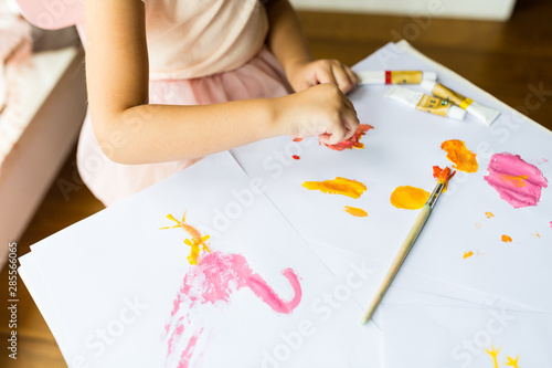 Portrait of a cute little girl painting hands at home. Learn, education, happy childhood concept
