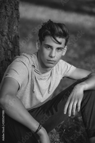 Portrait of a handsome teenager outdoors. A young man. Black and white photo
