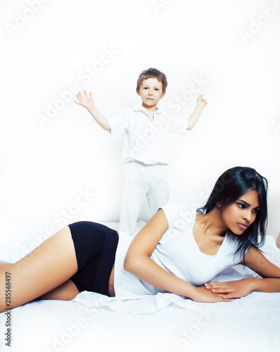 cute little boy in bed with mother in pajamas having fun happy smiling, lifestyle people concept