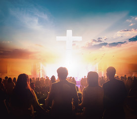 Worship concept: Group of people holding hands praying worship at sunset background