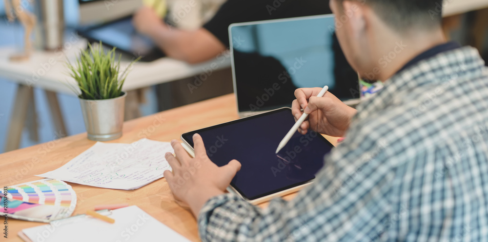 Male designer working on his project with tablet Male designer working on his project with tablet