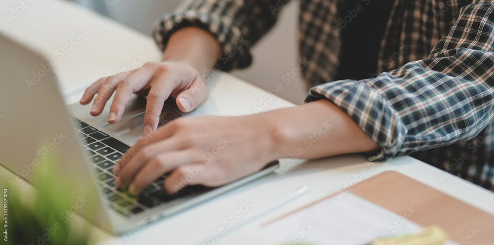 Young professional designer typing on laptop computer