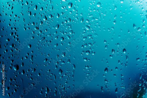 Water drops on window with blue background