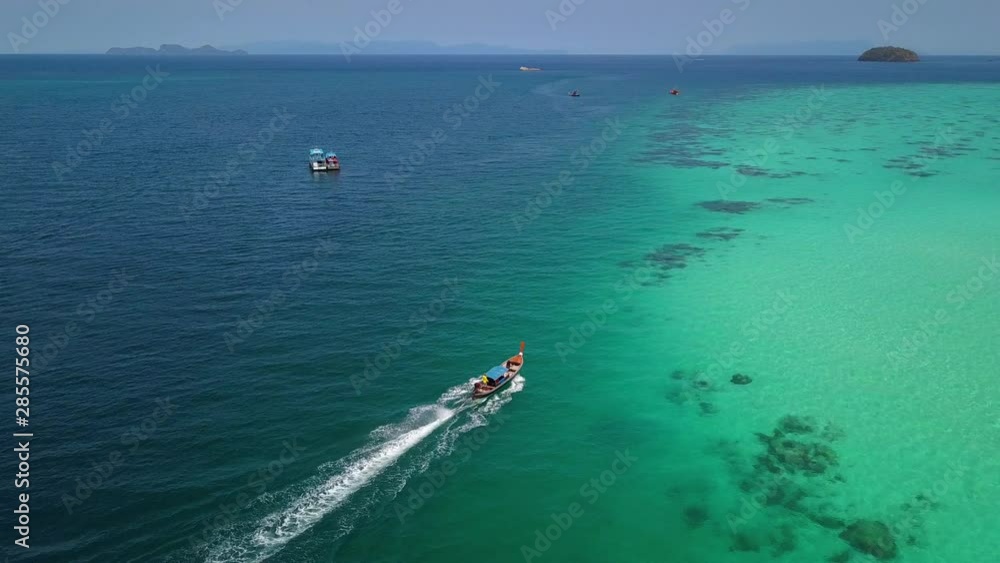 Aerial view of long-tailed boat is sail on the emerald sea. Water traffic with calm andaman sea at Koh Lipe, Satun, Thailand. Dolly motion. Aerial view of long-tailed boat is sail on the emerald sea. Water traffic with calm andaman sea at Koh Lipe, Satun, Thailand. Dolly motion.