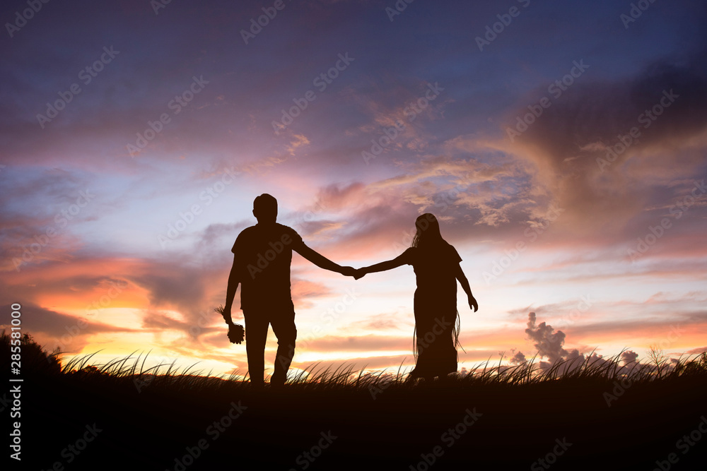 couple of young people walking in the sunset