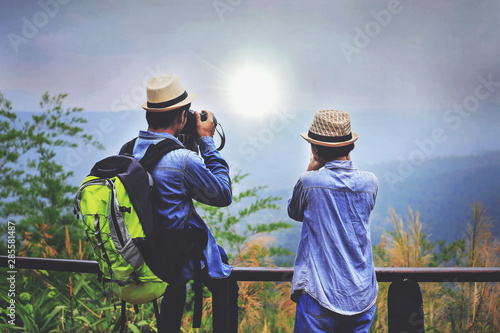Asian tourists are Take a picture of the sunset in the evening on the mountain