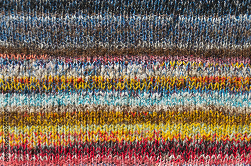 background of bright multi color striped fabric knitted by the hand