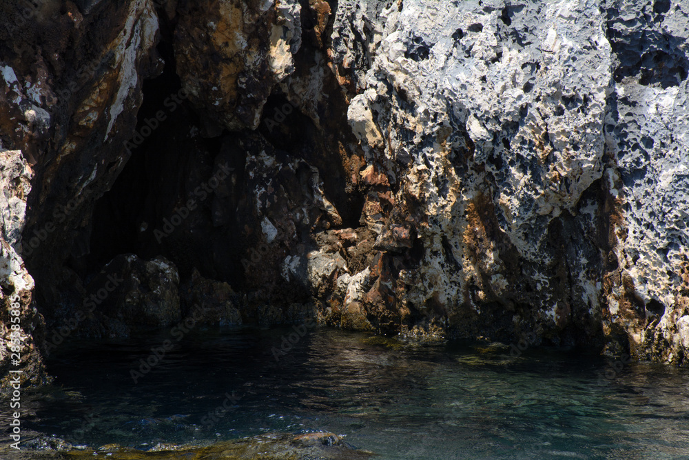 Mediterranean Sea. In the coastal cliffs a dark grotto. Concept - the secret of time Mediterranean Sea. In the coastal cliffs a dark grotto. Concept - the secret of time