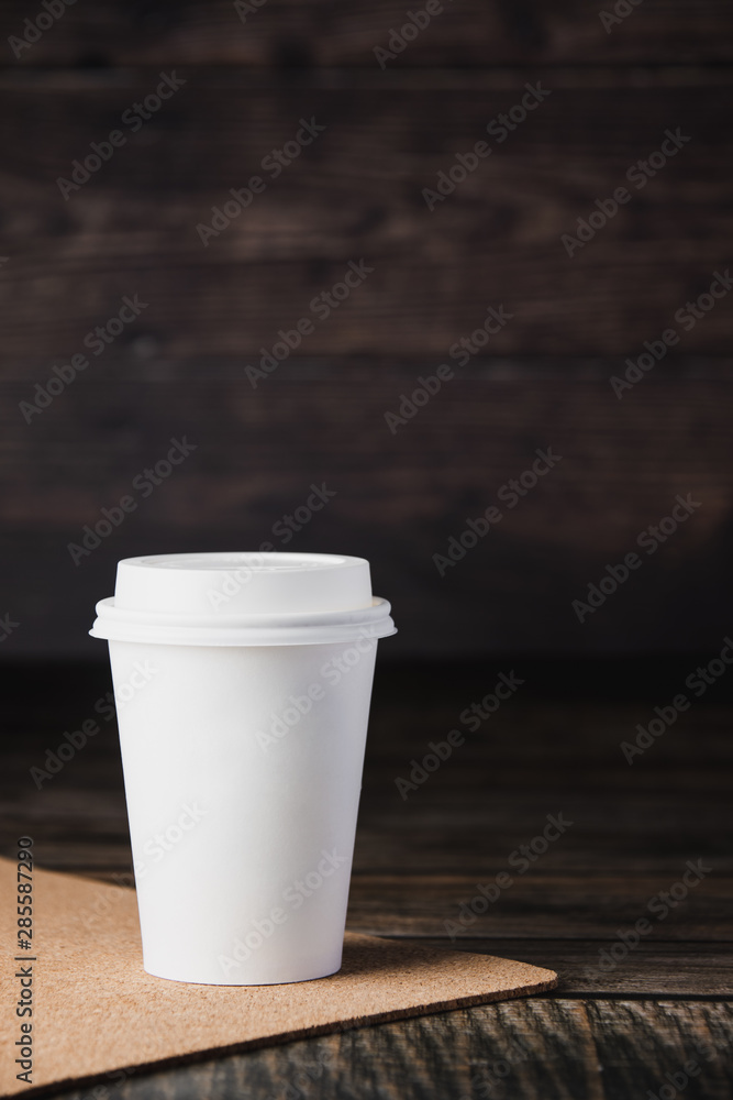 Takeaway cup of coffee on brown wooden background Takeaway cup of coffee on brown wooden background
