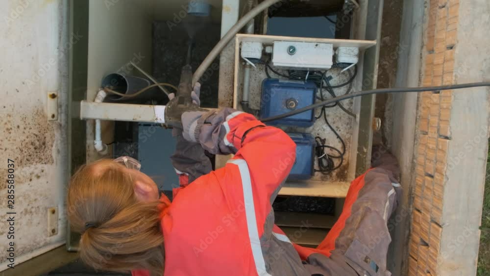 woman worker in uniform serves an autonomous sewer. top view. Processing station biological water purification. woman worker in uniform serves an autonomous sewer. top view. Processing station biological water purification.