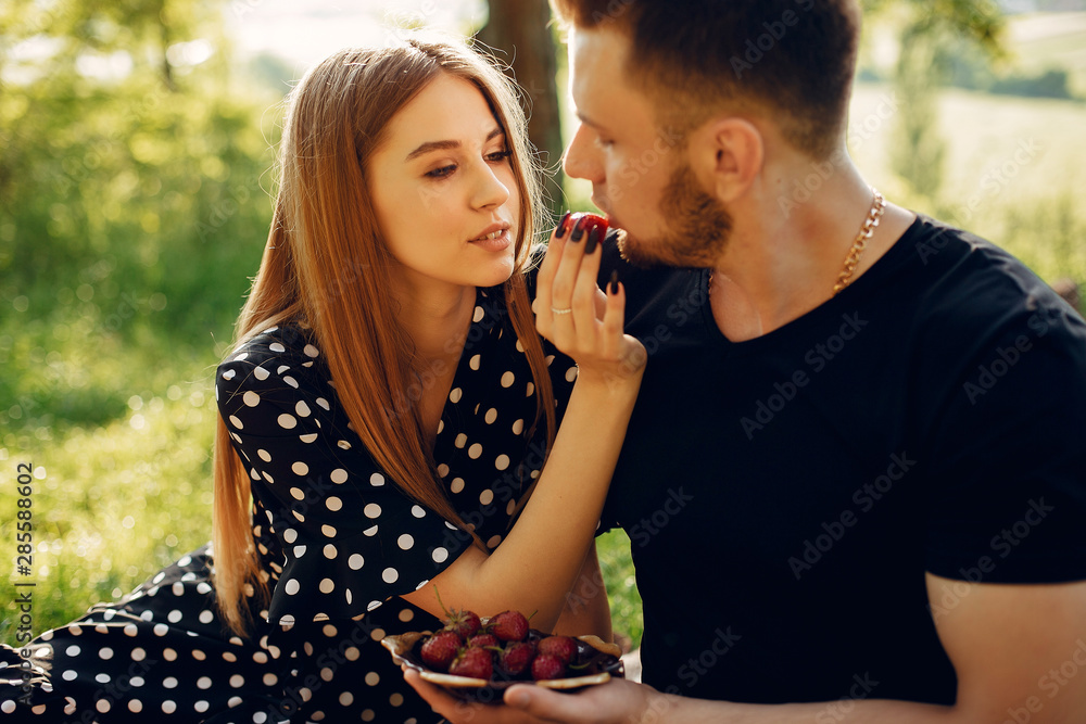 Cute couple in a park. Lady in a black dress. Guy in a black shirt. Cute couple in a park. Lady in a black dress. Guy in a black shirt.
