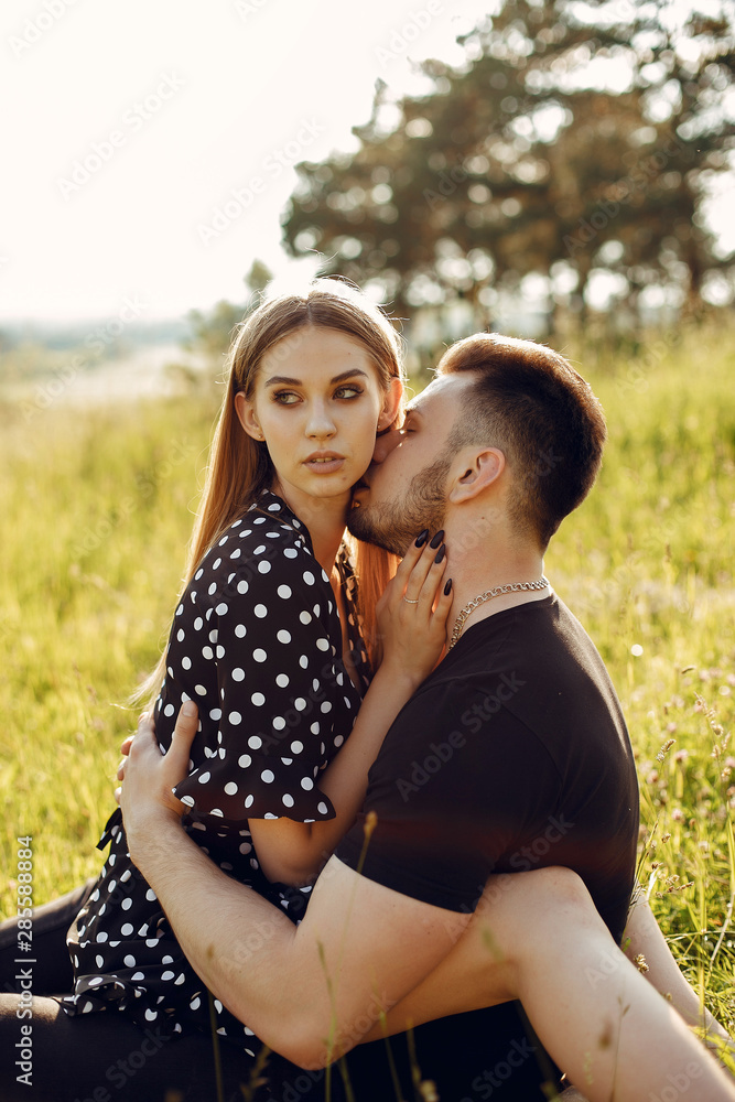 Cute couple in a park. Lady in a black dress. Guy in a black t-shirt. Cute couple in a park. Lady in a black dress. Guy in a black t-shirt.