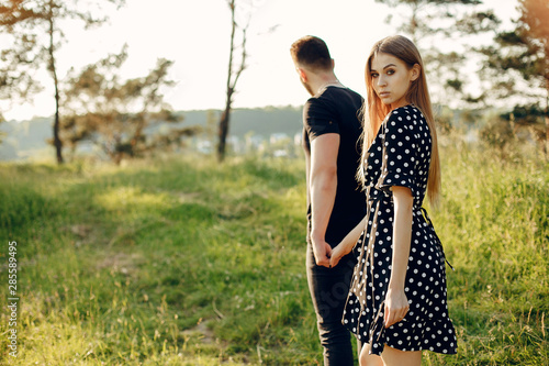 Cute couple in a park. Lady in a black dress. Guy in a black t-shirt.