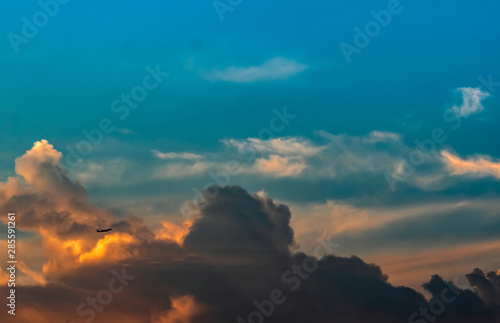 Beautiful blue and orange sunset sky. Aircraft flying on colorful sunrise. Art picture of sky at sunrise. Sunrise and clouds for inspiration background. Peaceful and tranquil concept.