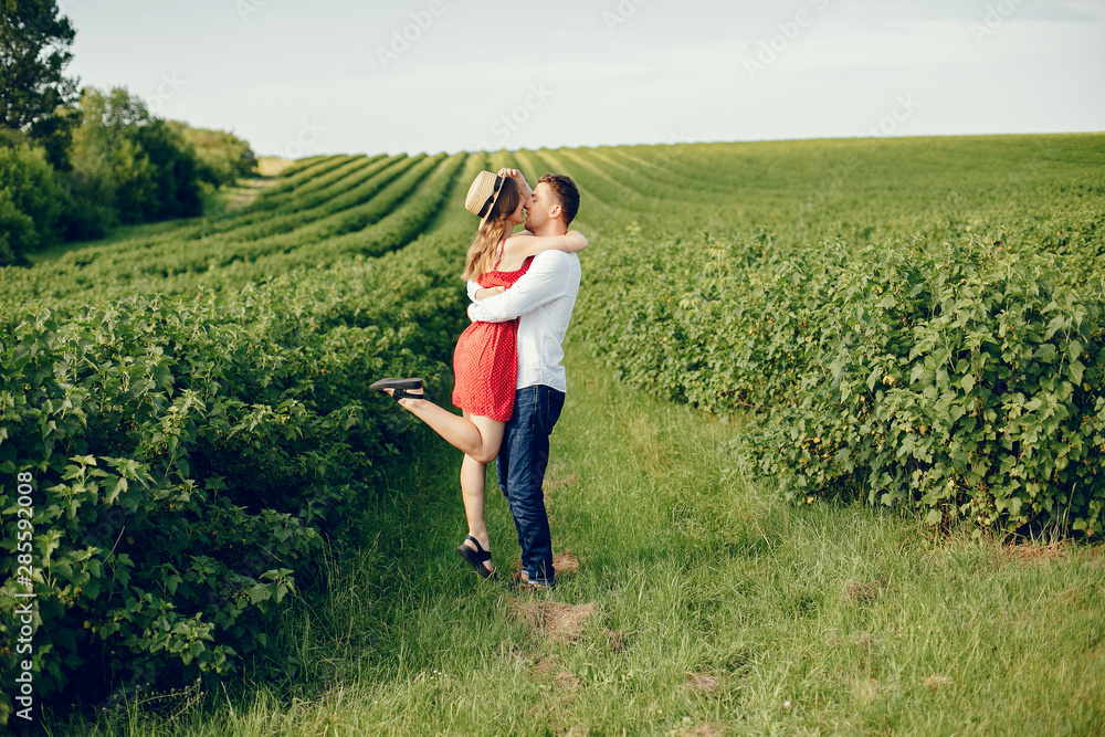 Couple in a field. Girl in a red dress. Man in a white shirt Couple in a field. Girl in a red dress. Man in a white shirt