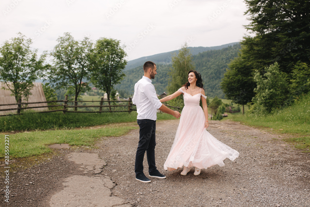 Beautiful wedding couple in Carpathian mountains. Handsome man with attractive woman. Bride spin around