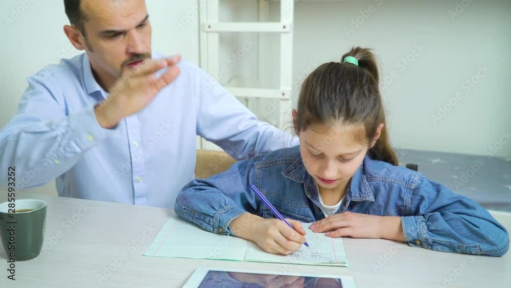 angry father is annoyed with his daughter doing homework angry father is annoyed with his daughter doing homework