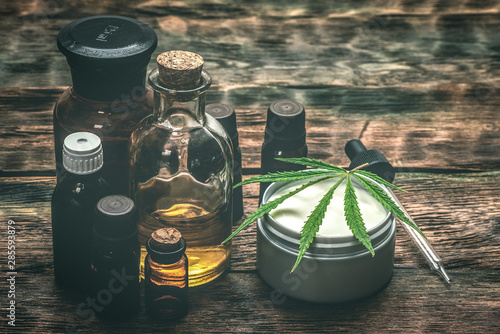 Cannabis face cream or moisturizer jar and cbd oil bottles concept. photo