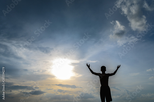 Wallpaper Mural The boy raised his hand in the sky to ask for rain during the sunset. Torontodigital.ca