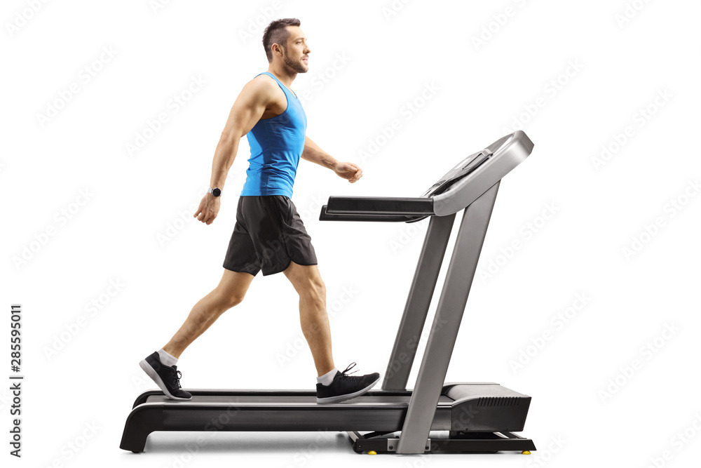 Fototapeta premium Young man walking on a professional treadmill