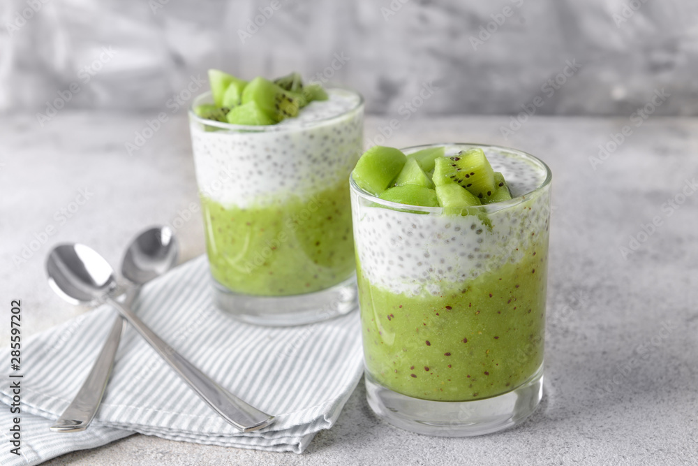 Glasses with tasty kiwi dessert on grey background Glasses with tasty kiwi dessert on grey background