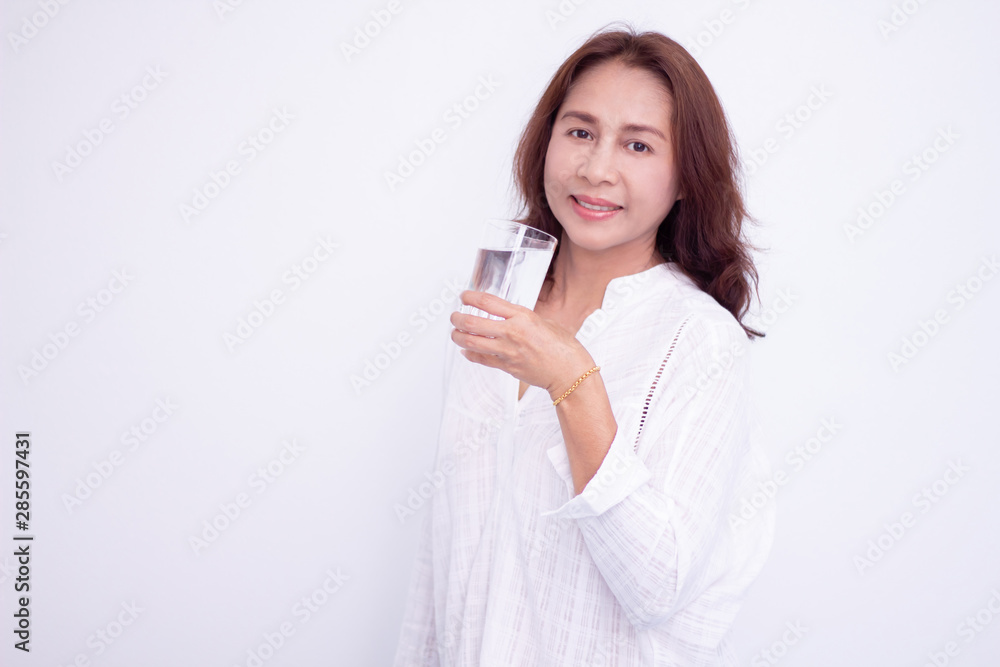 Happy young woman showing drinking glass with water at home. Happy young woman showing drinking glass with water at home.